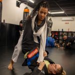 Duas mulheres treinam jiu-jitsu em um ambiente esportivo