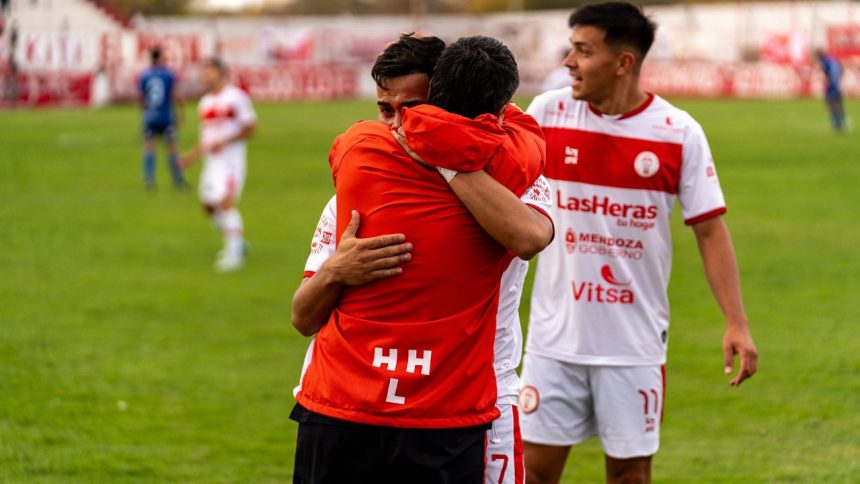 Jogadores de futebol comemoram uma vitória no campo, abraçados e demonstrando alegria.