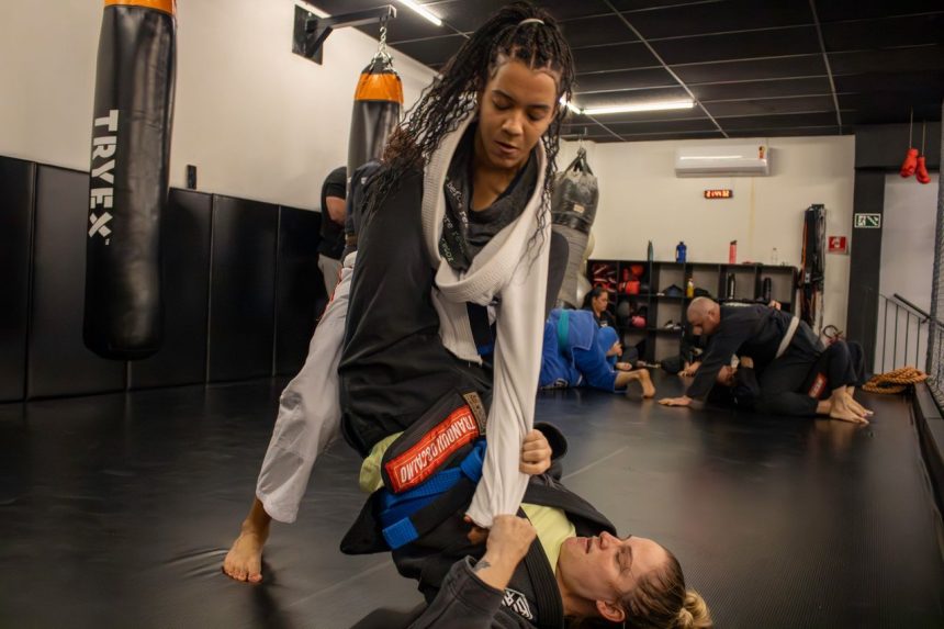 Duas mulheres treinam jiu-jitsu em um ambiente esportivo